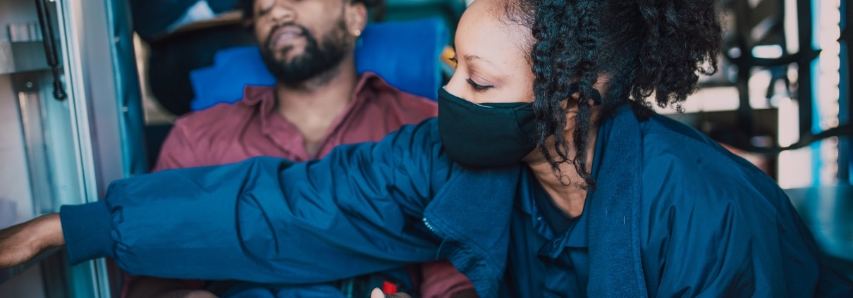 Female paramedic taking a man's vitals