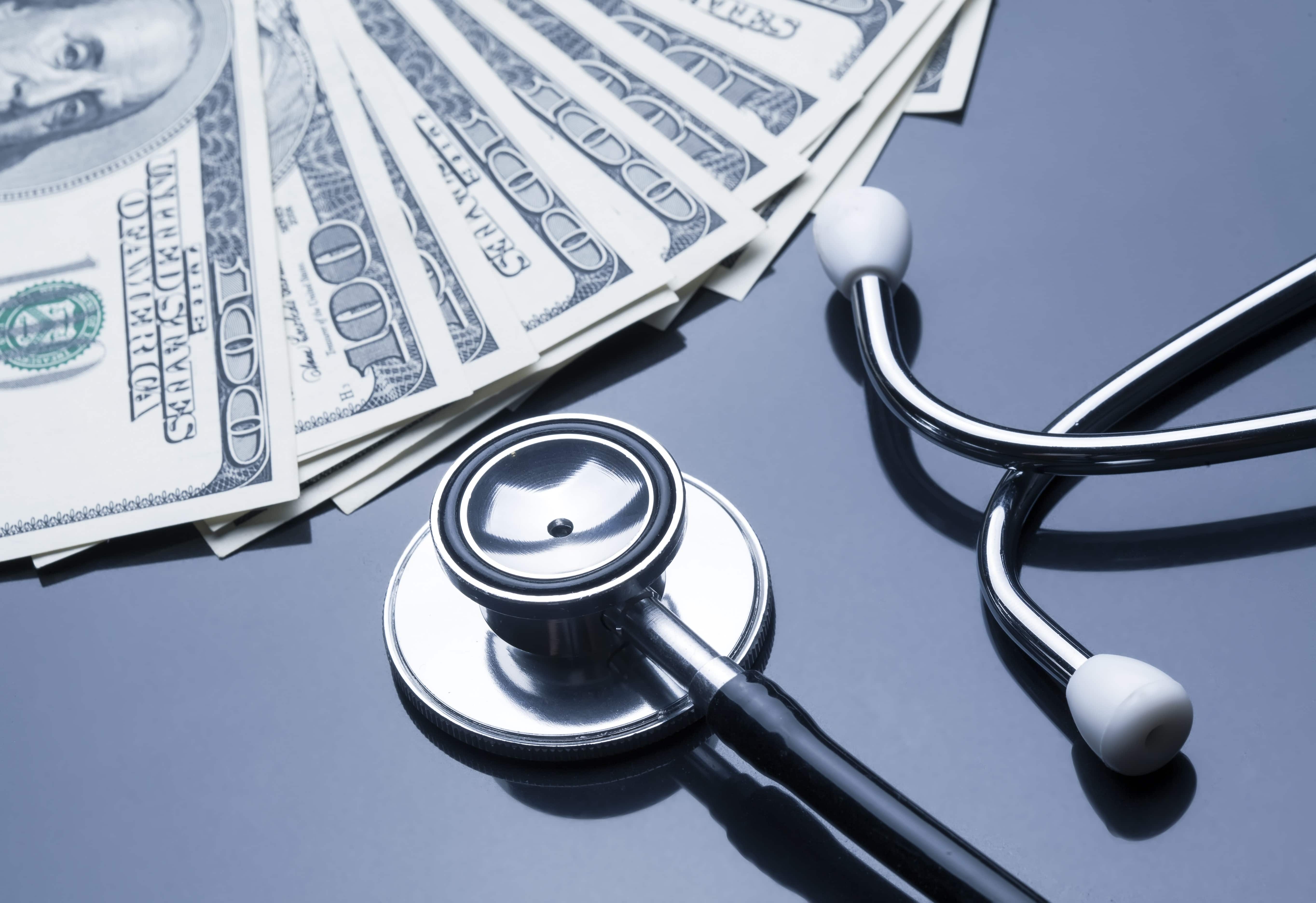 Stethoscope next to stack of money