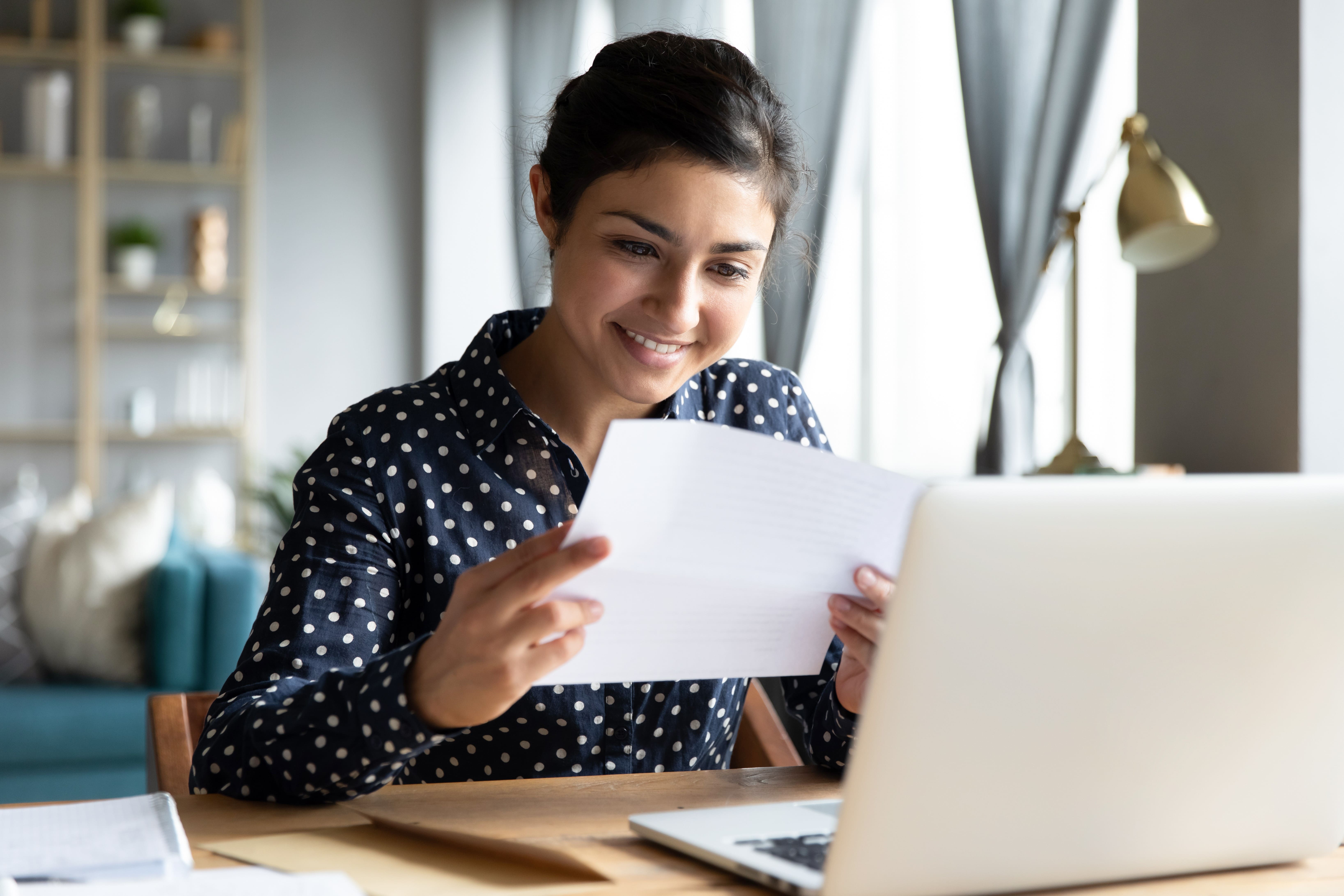 Smiling young woman holding a piece of paper
