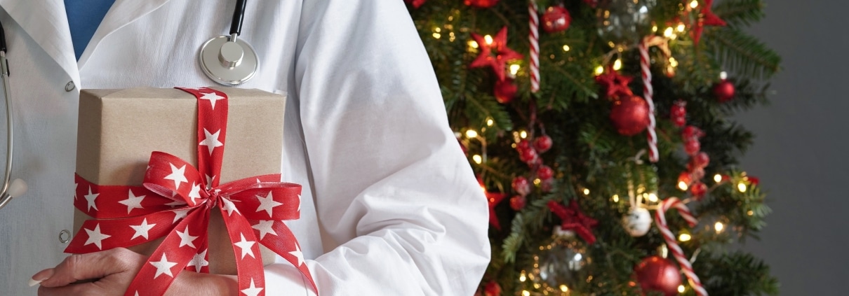 Medical professional in front of a Christmas tree