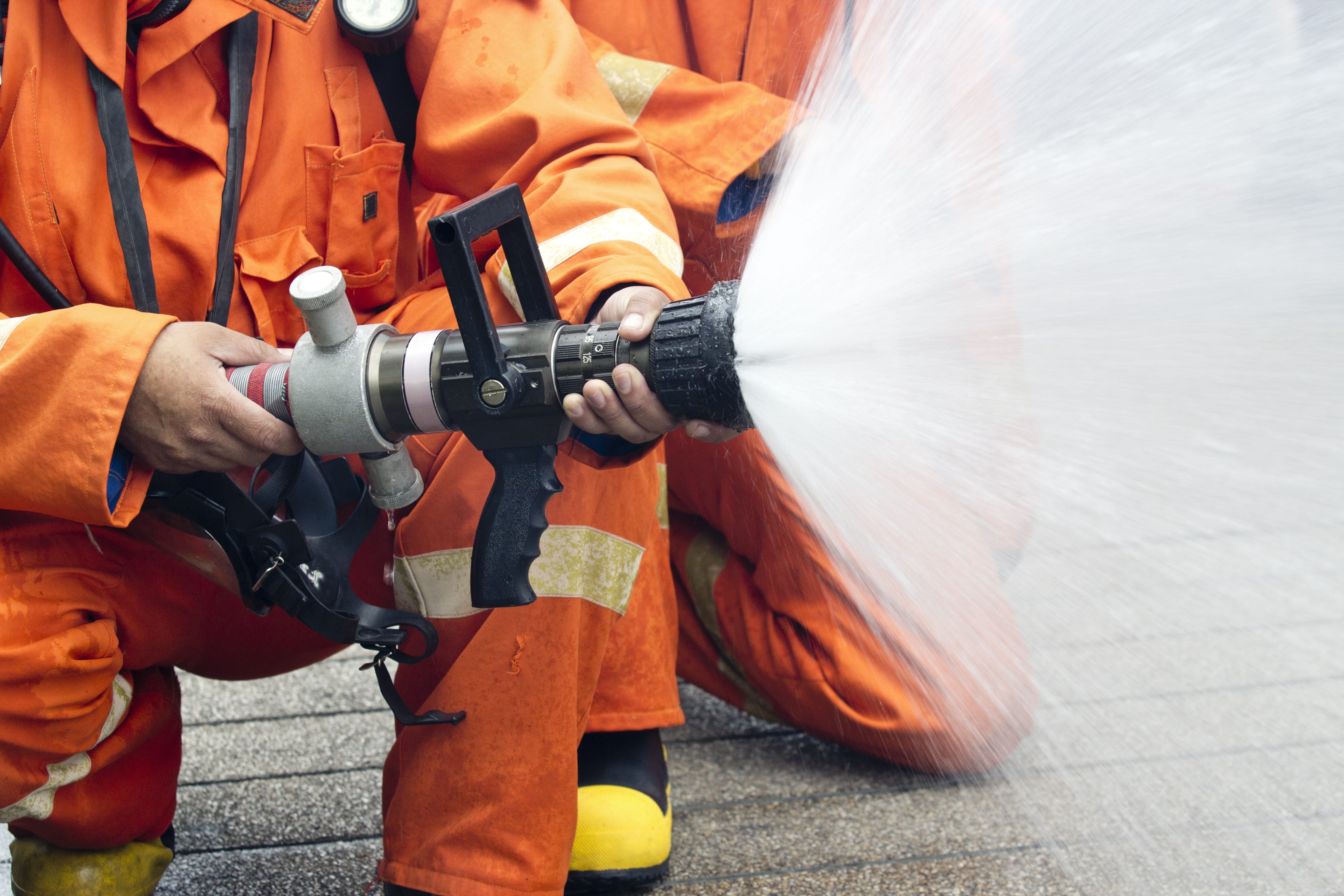 Close up of firefighters using a hose