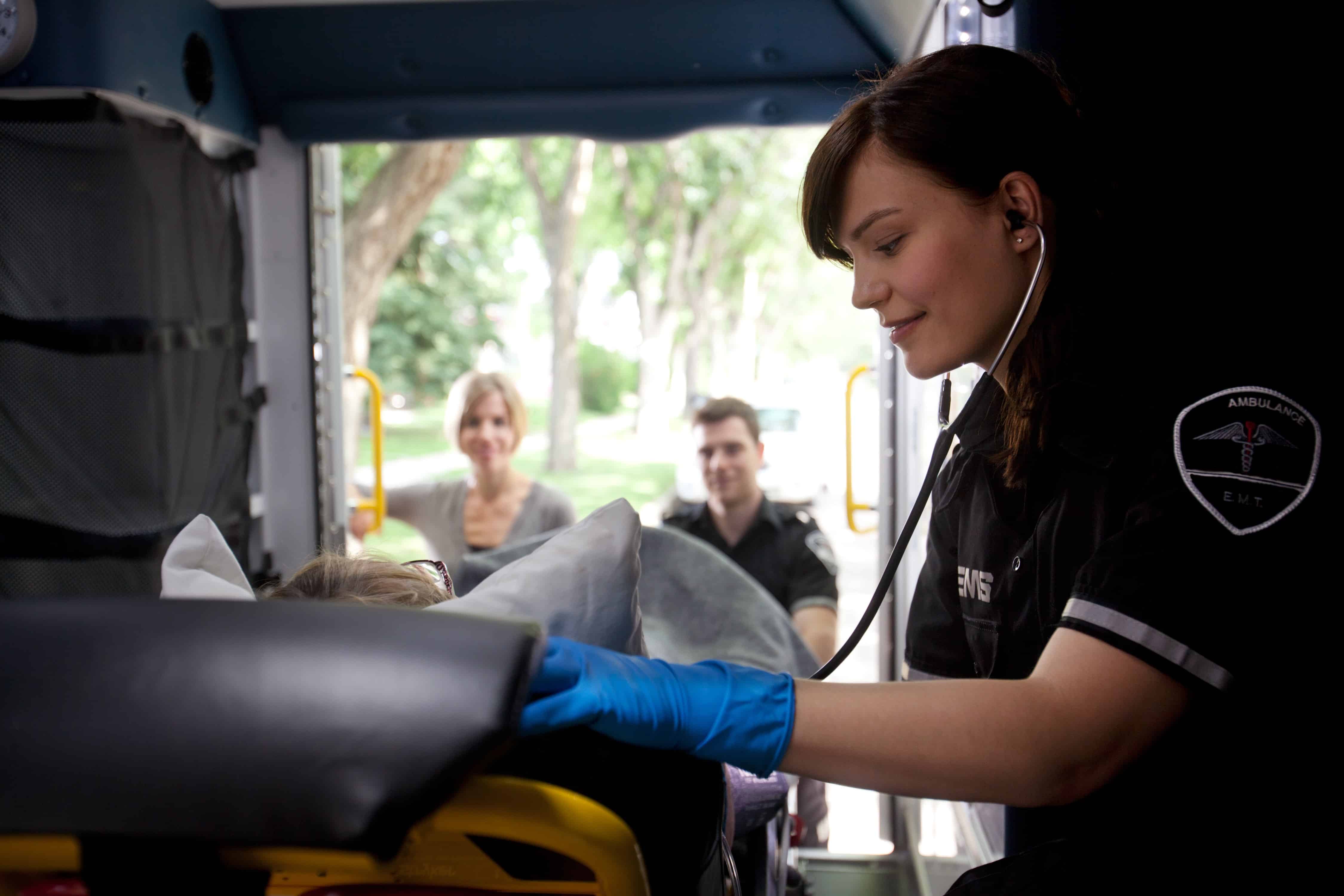 Female EMS worker using a stethoscope
