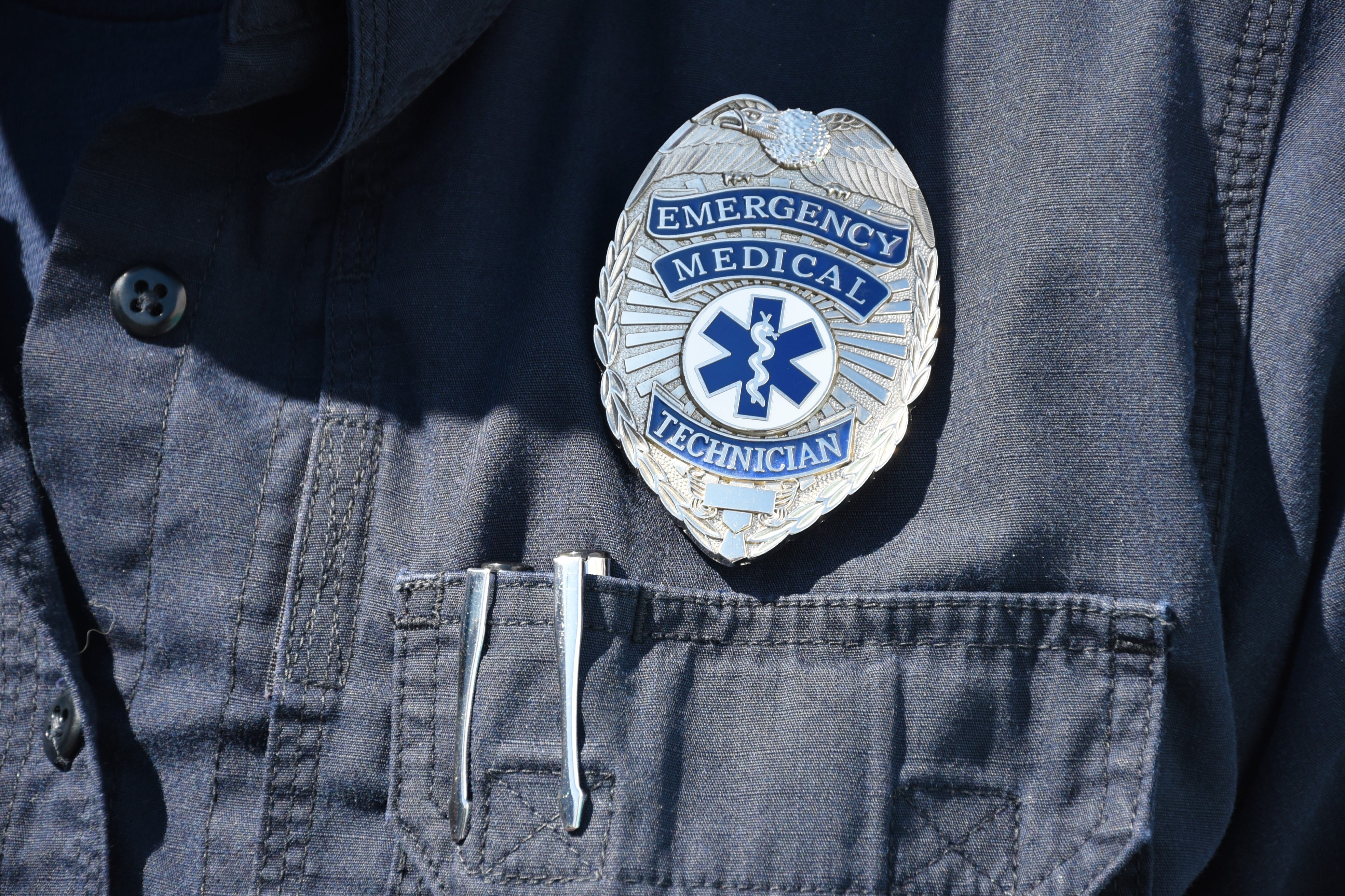 Close up of silver EMT badge