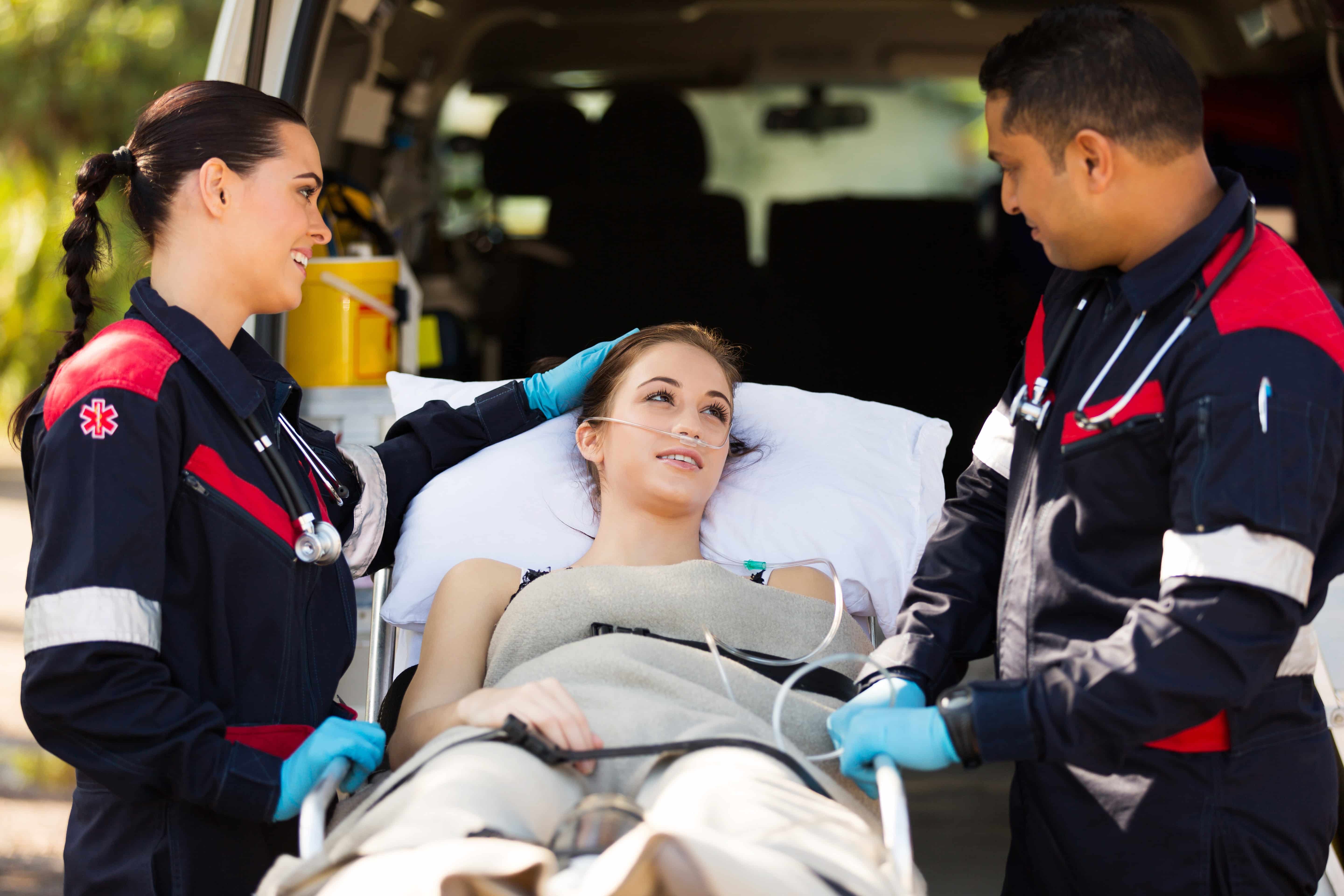 EMS professionals with a woman on a stretcher