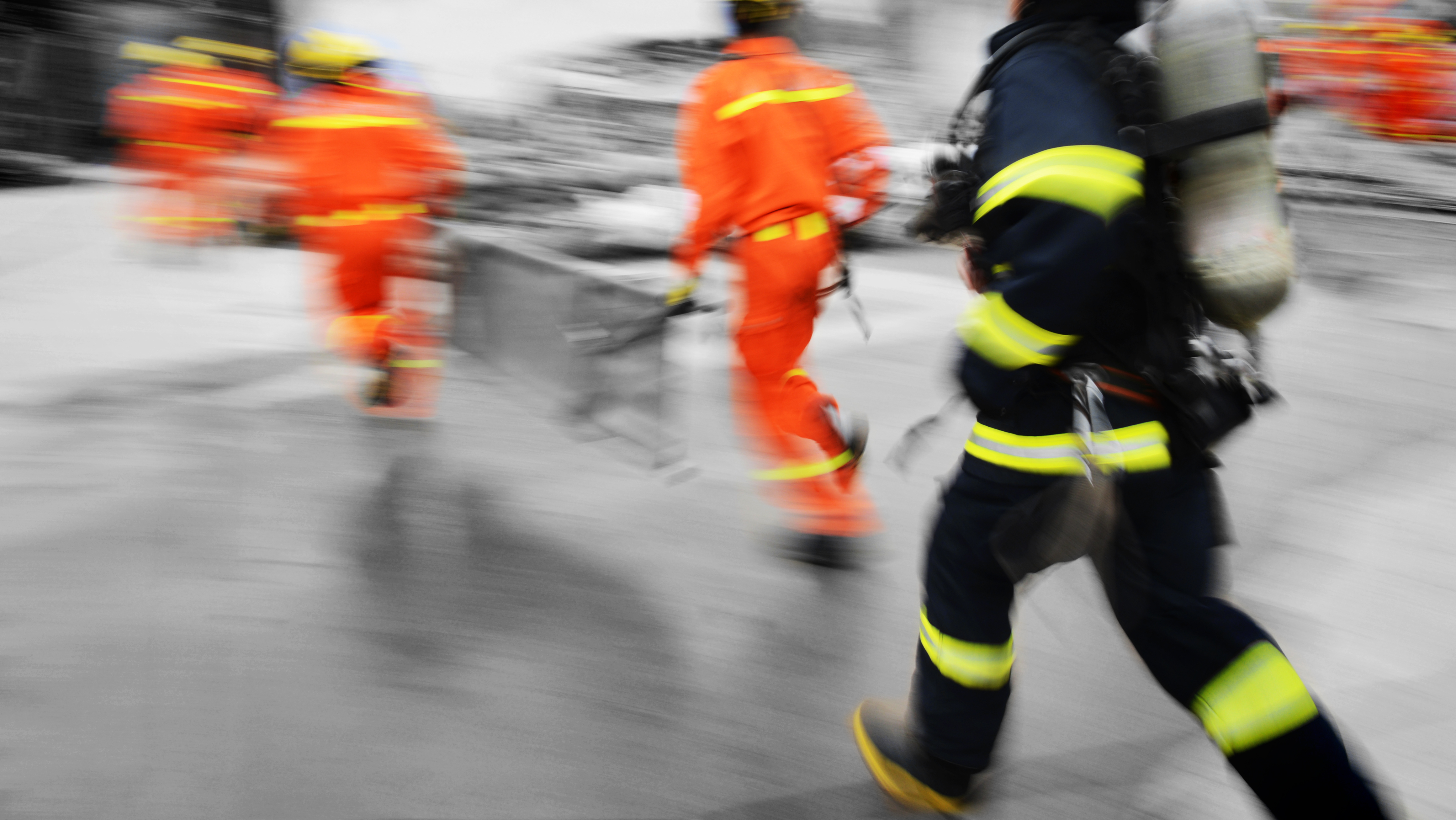 Blurred search and rescue team running to a building