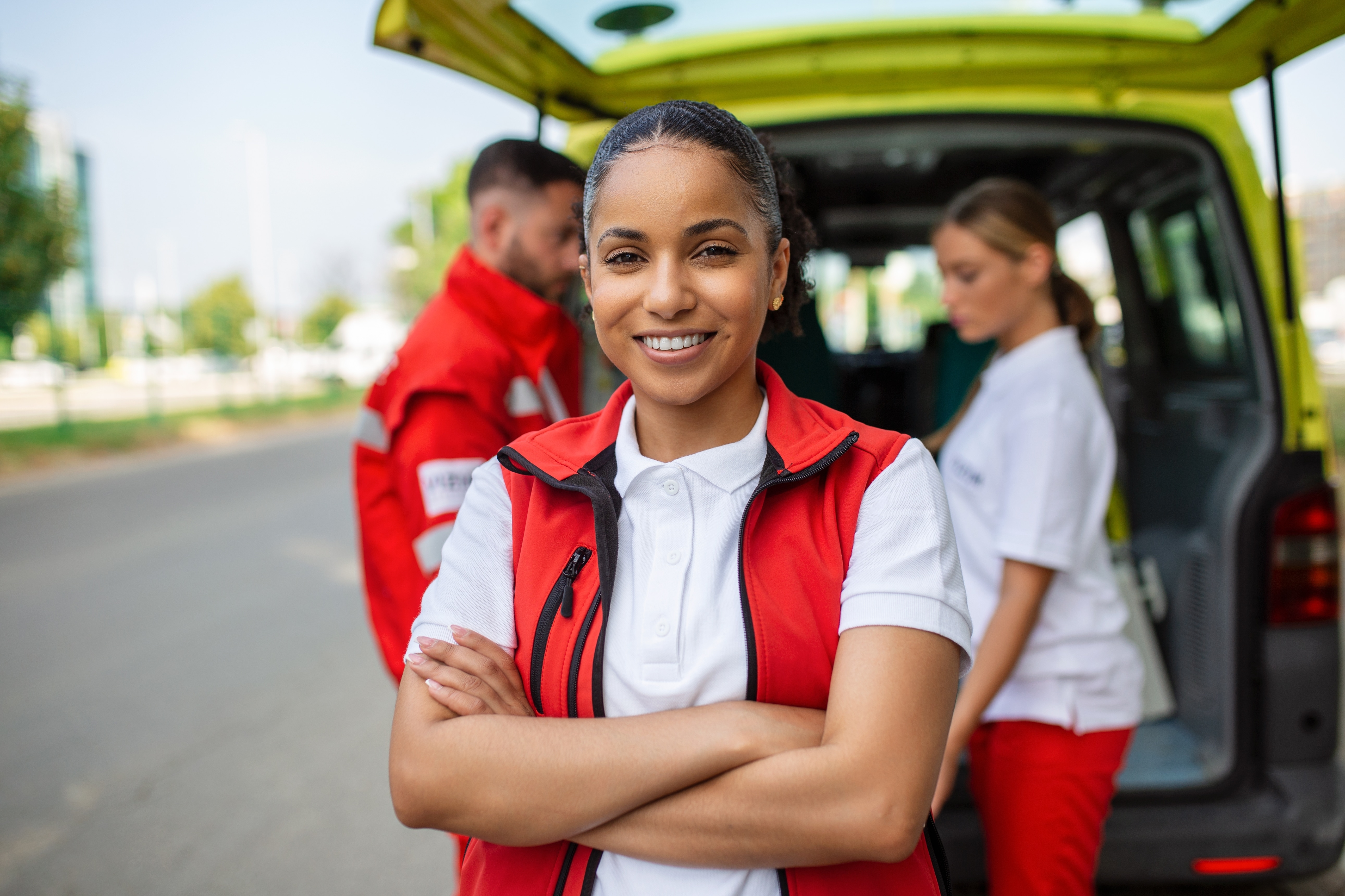 Smiling EMS professional in front of an ambulance