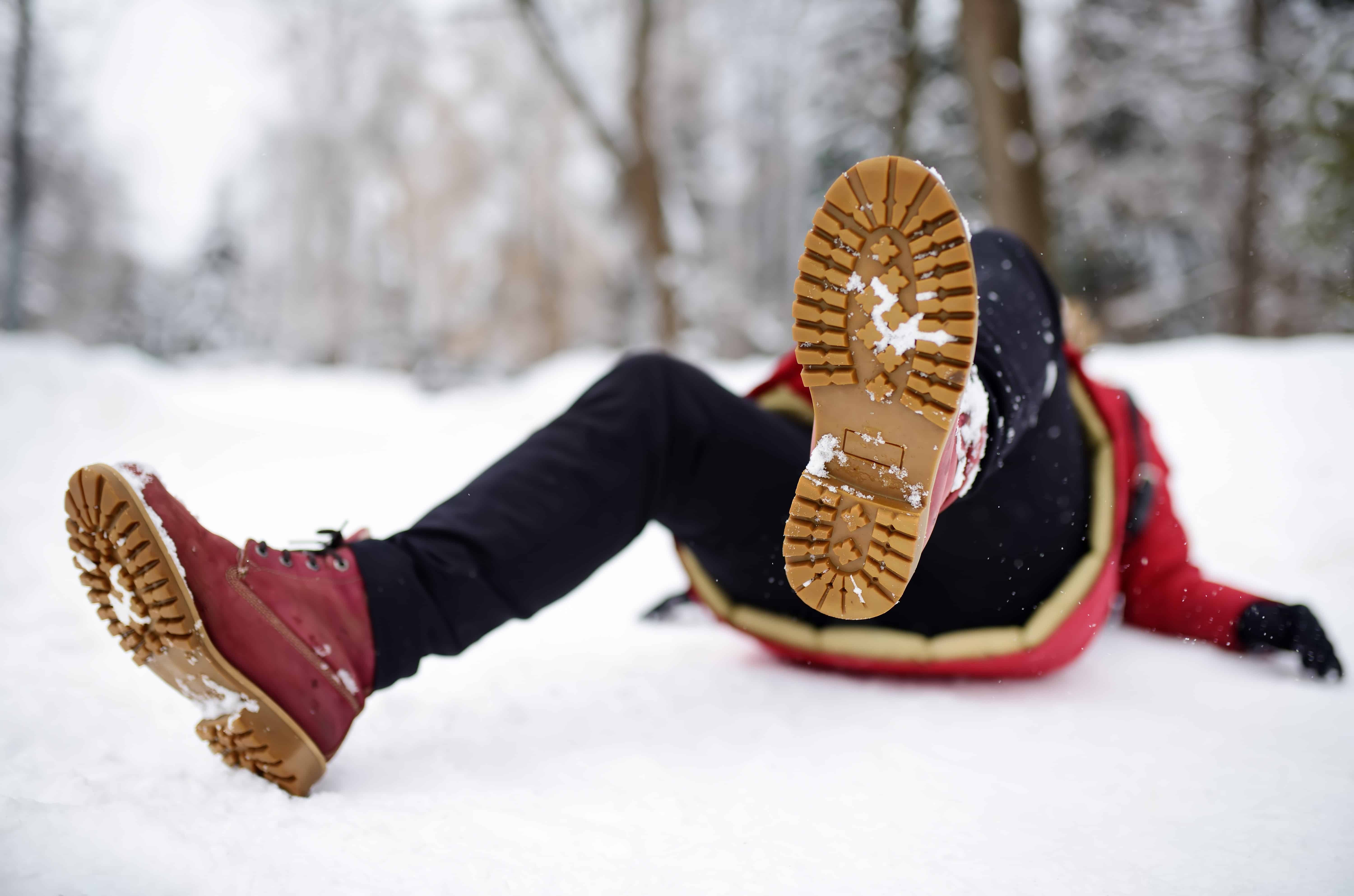 Woman in boots falling in the snow