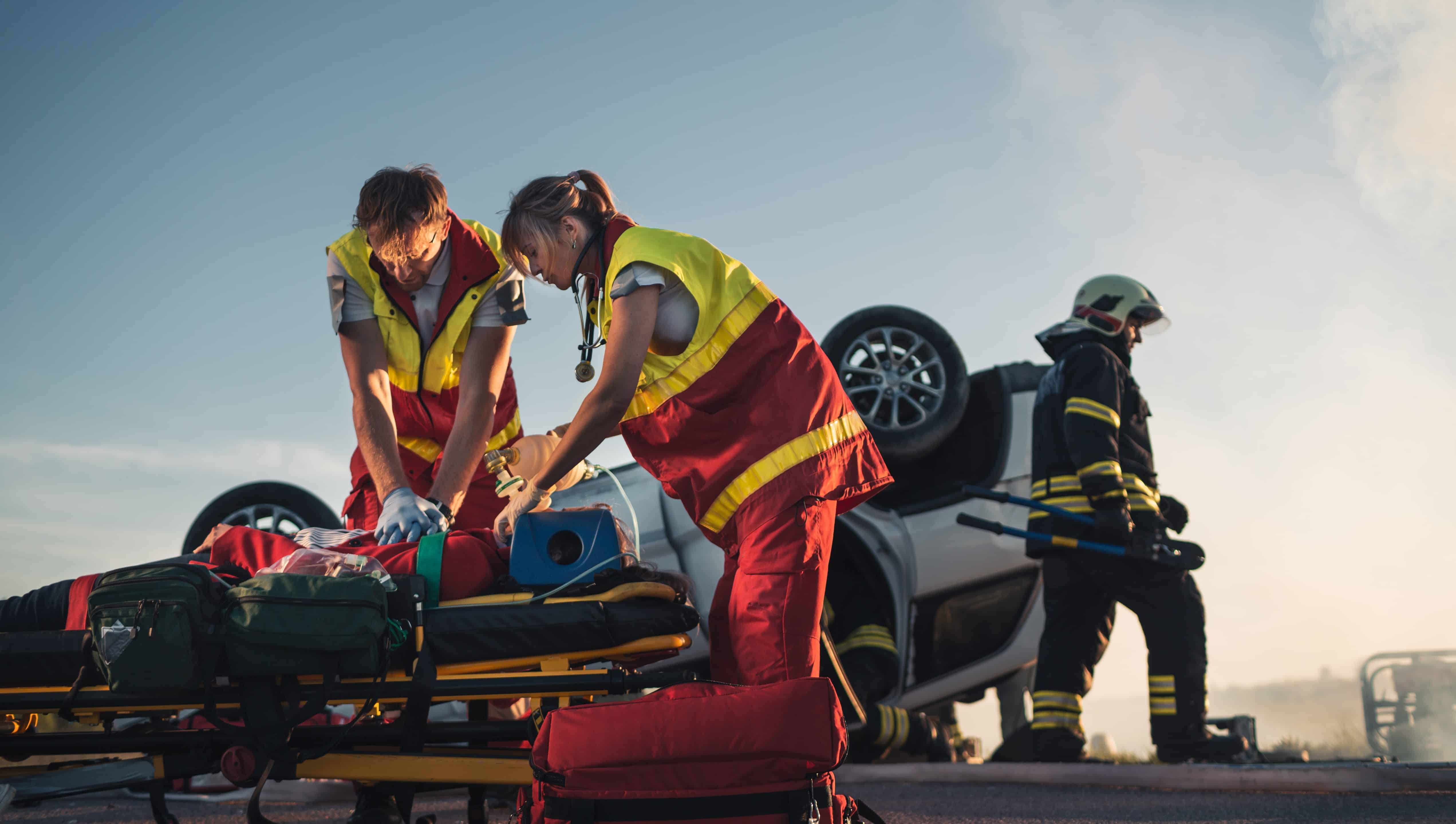 EMS professionals performing CPR at the scene of a car accident