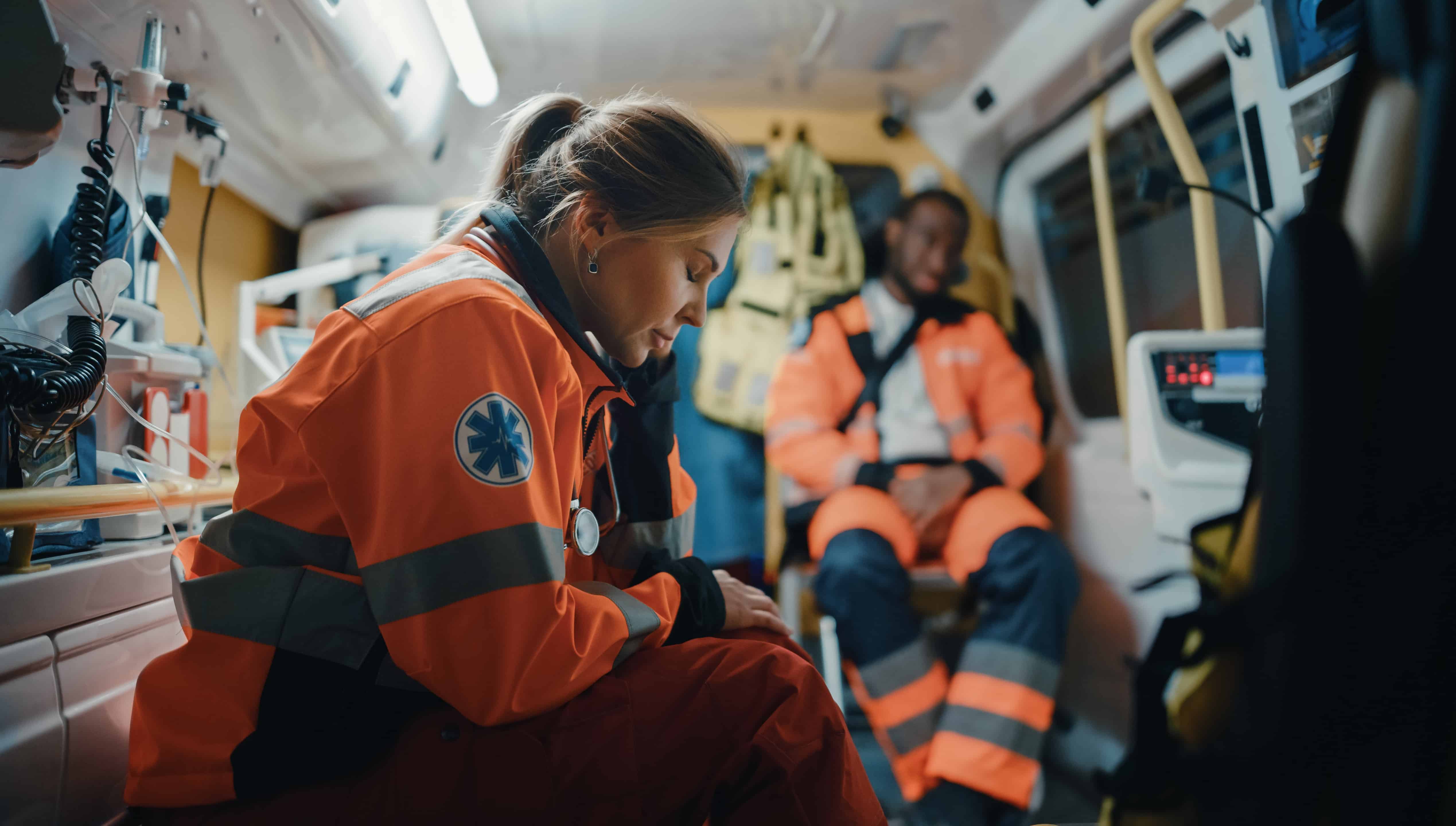 Female EMS professional closing her eyes in the ambulance