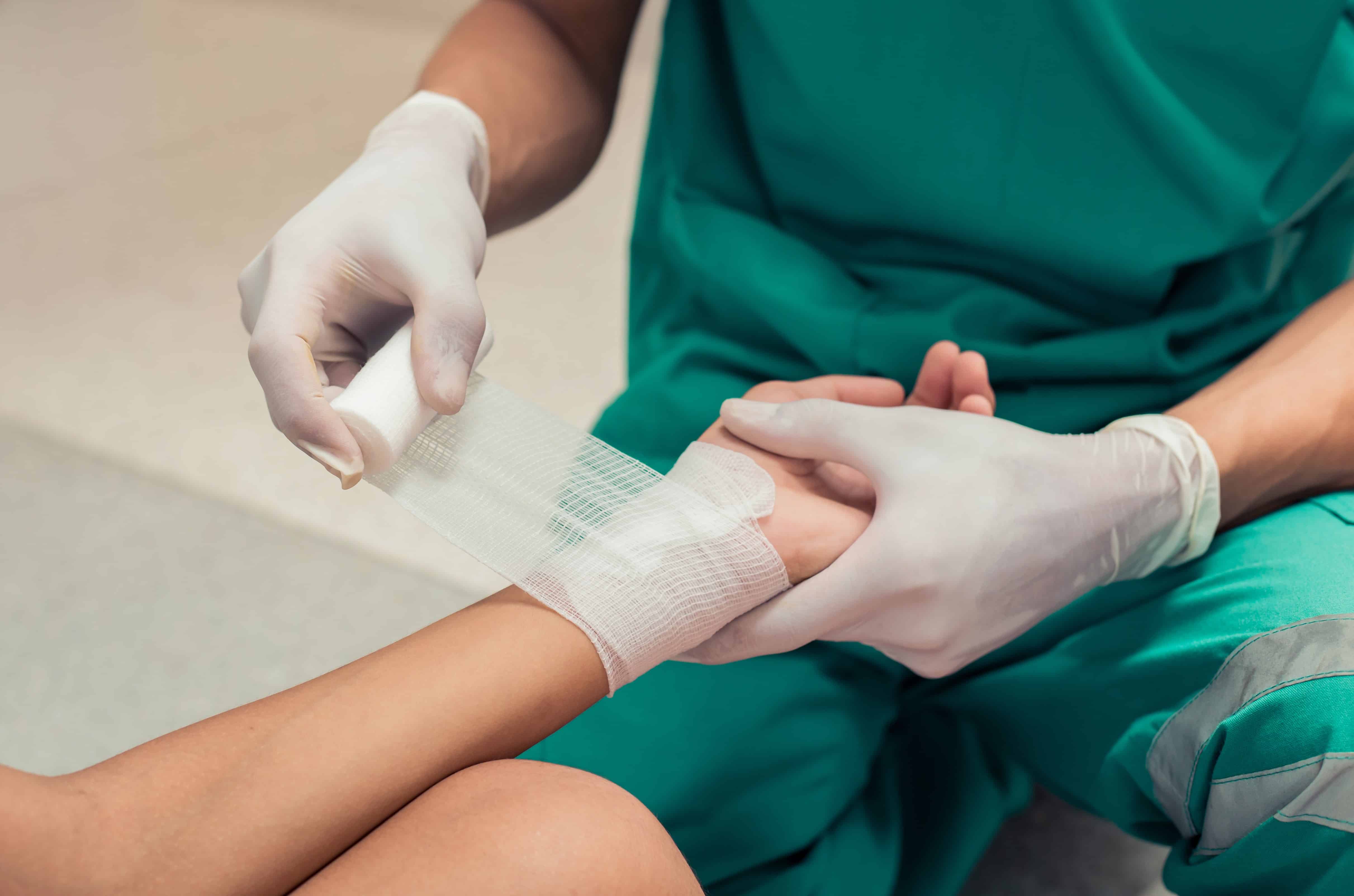 Medical professional wrapping a person's wrist with bandages