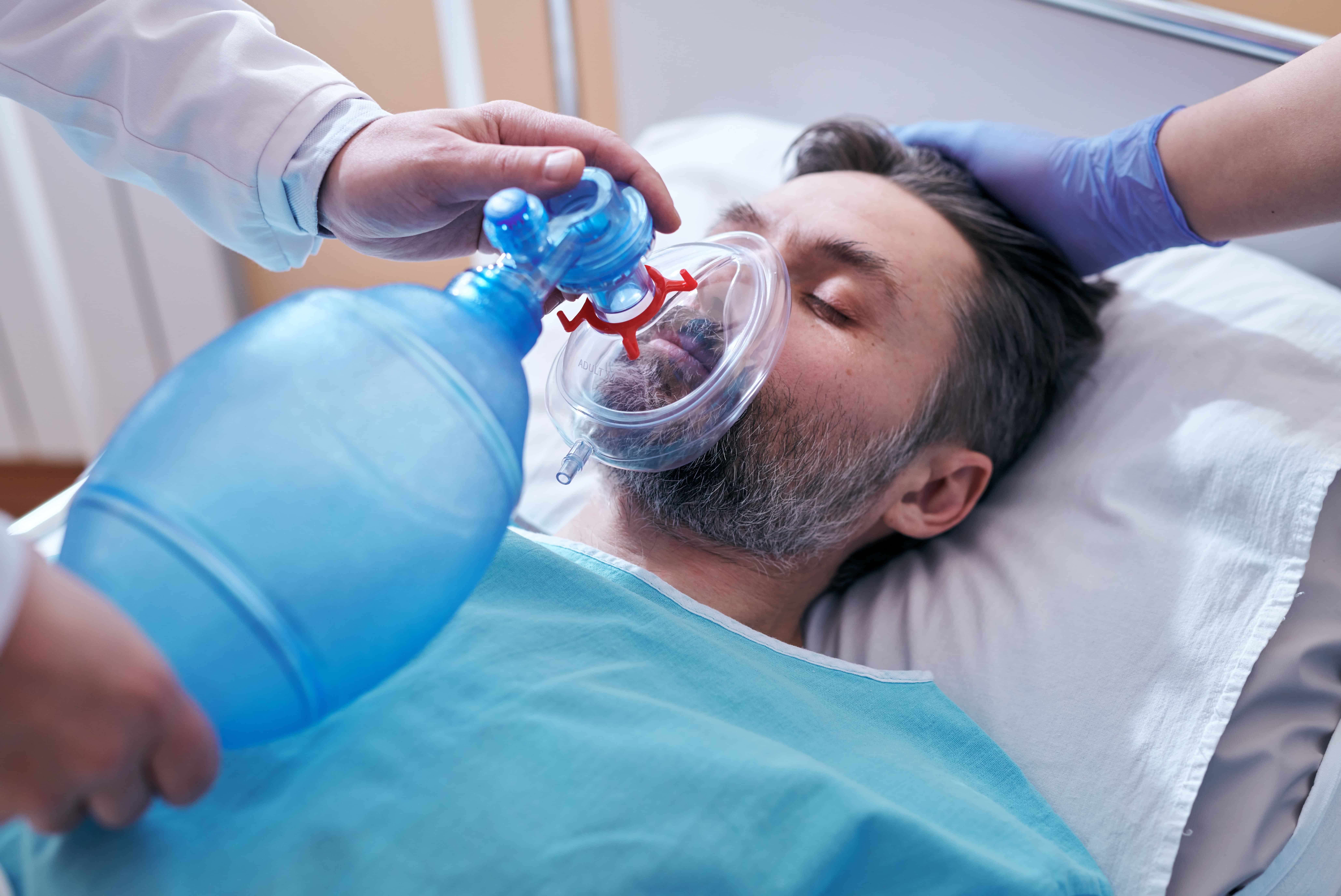 Medical professional using a Bag Valve Mask on a male patient