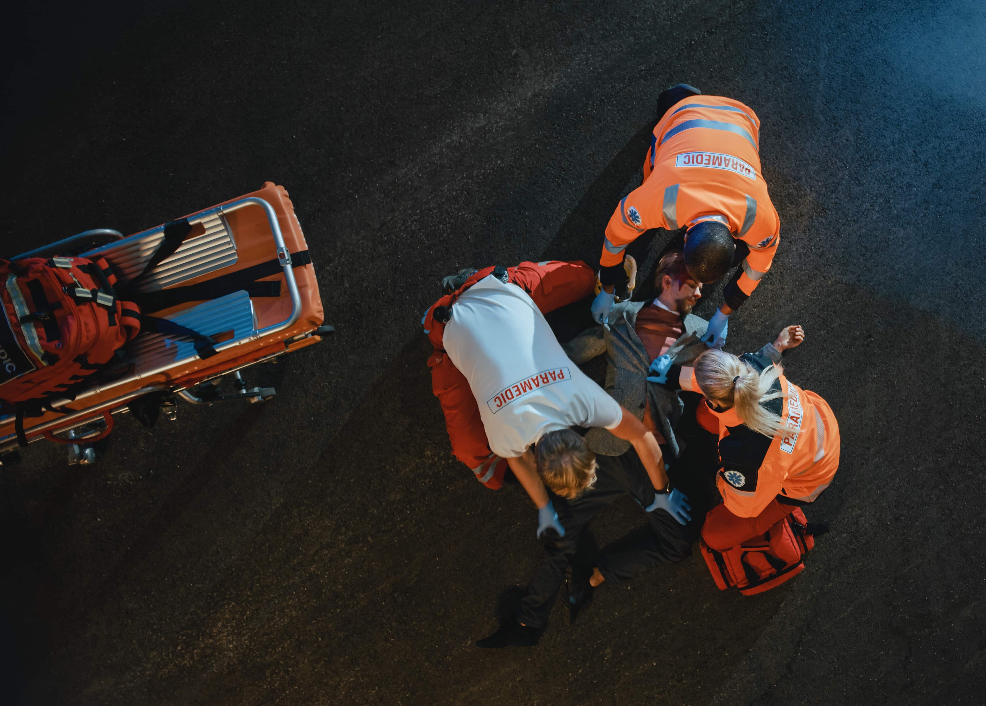 Aerial view of paramedics helping a man collapsed on the street