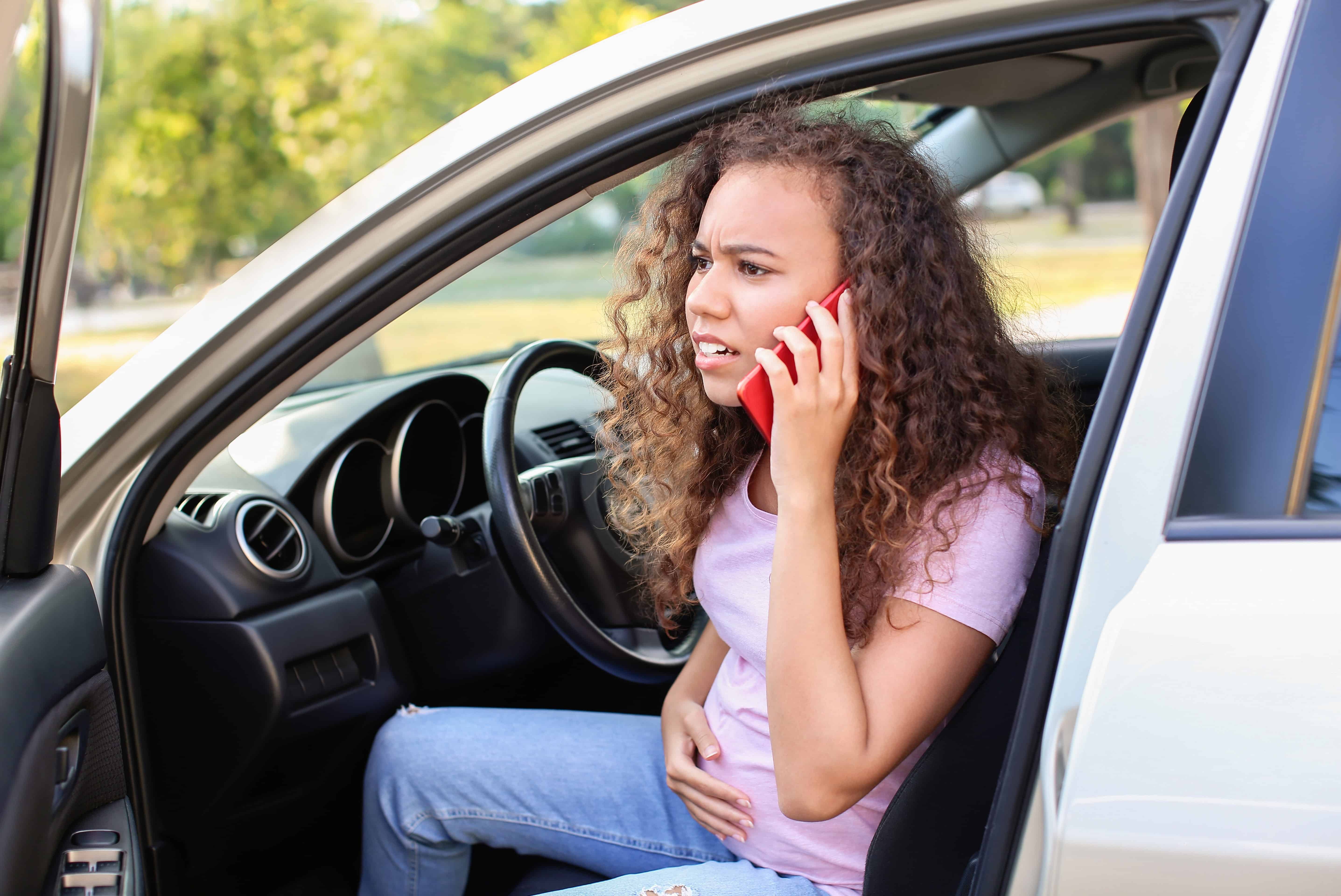 Pregnant African-American woman sitting in a car