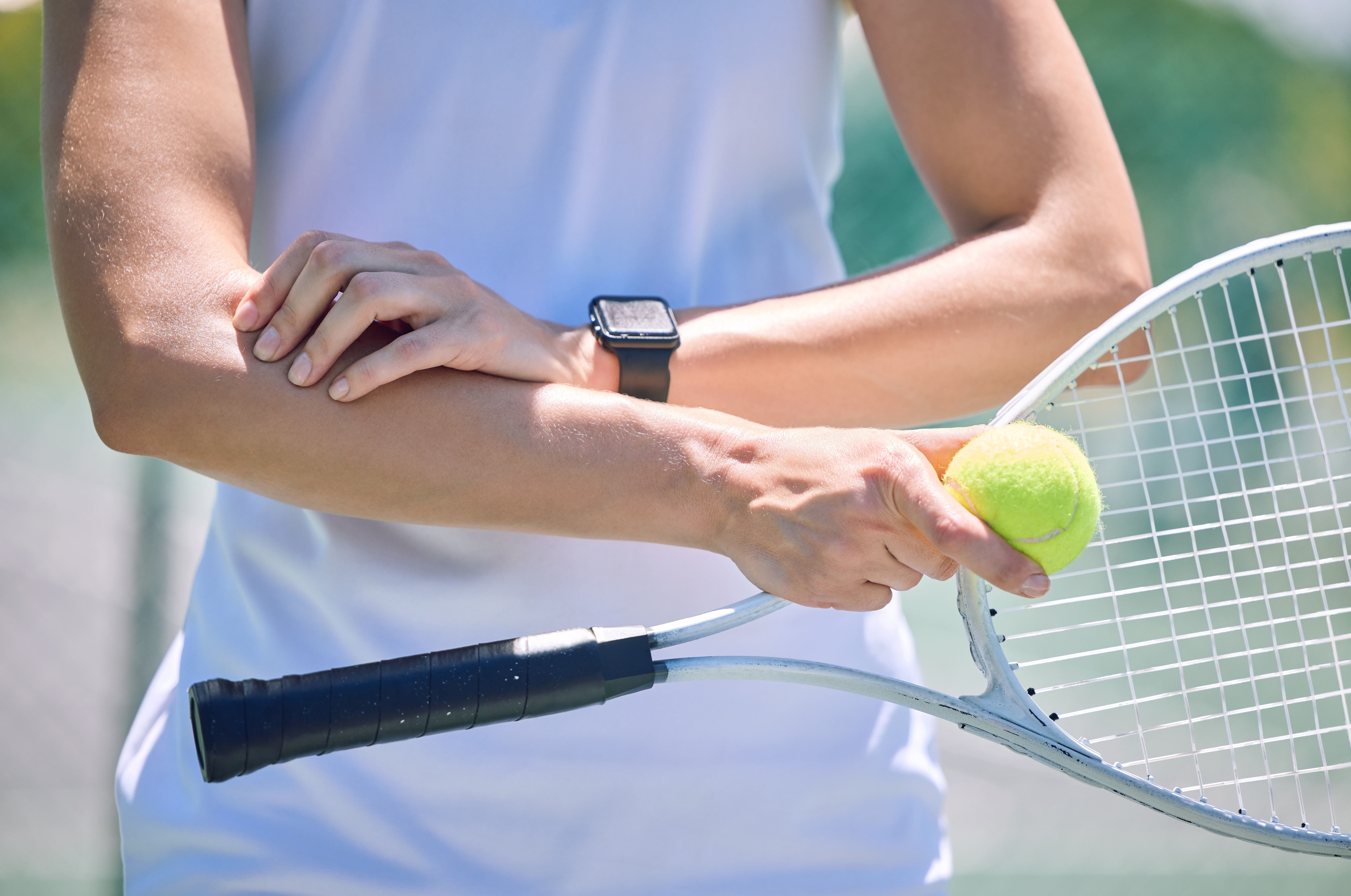 Close up of a tennis player gripping their arm
