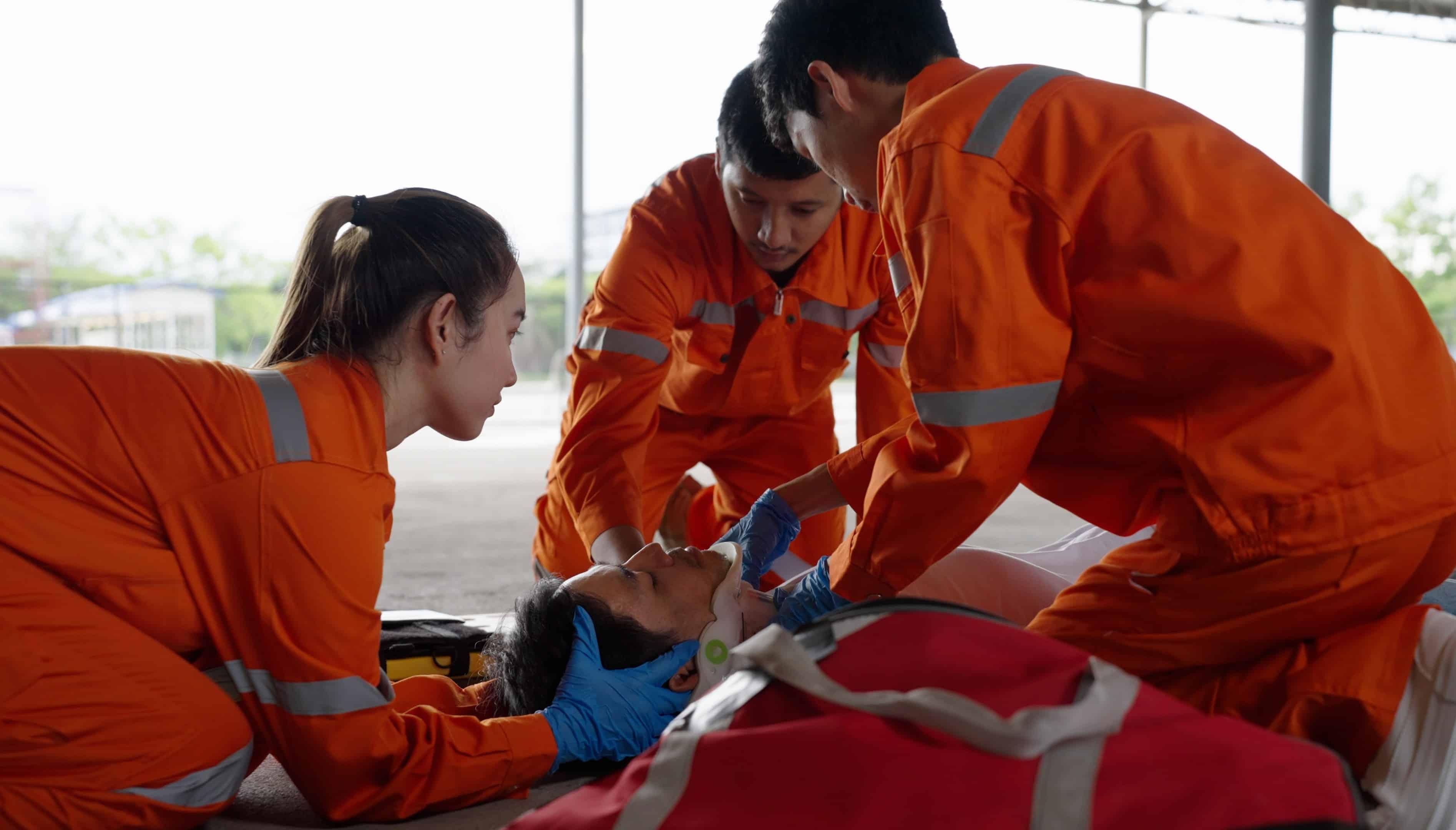 Team of EMS professionals stabilizing a man on a stretcher