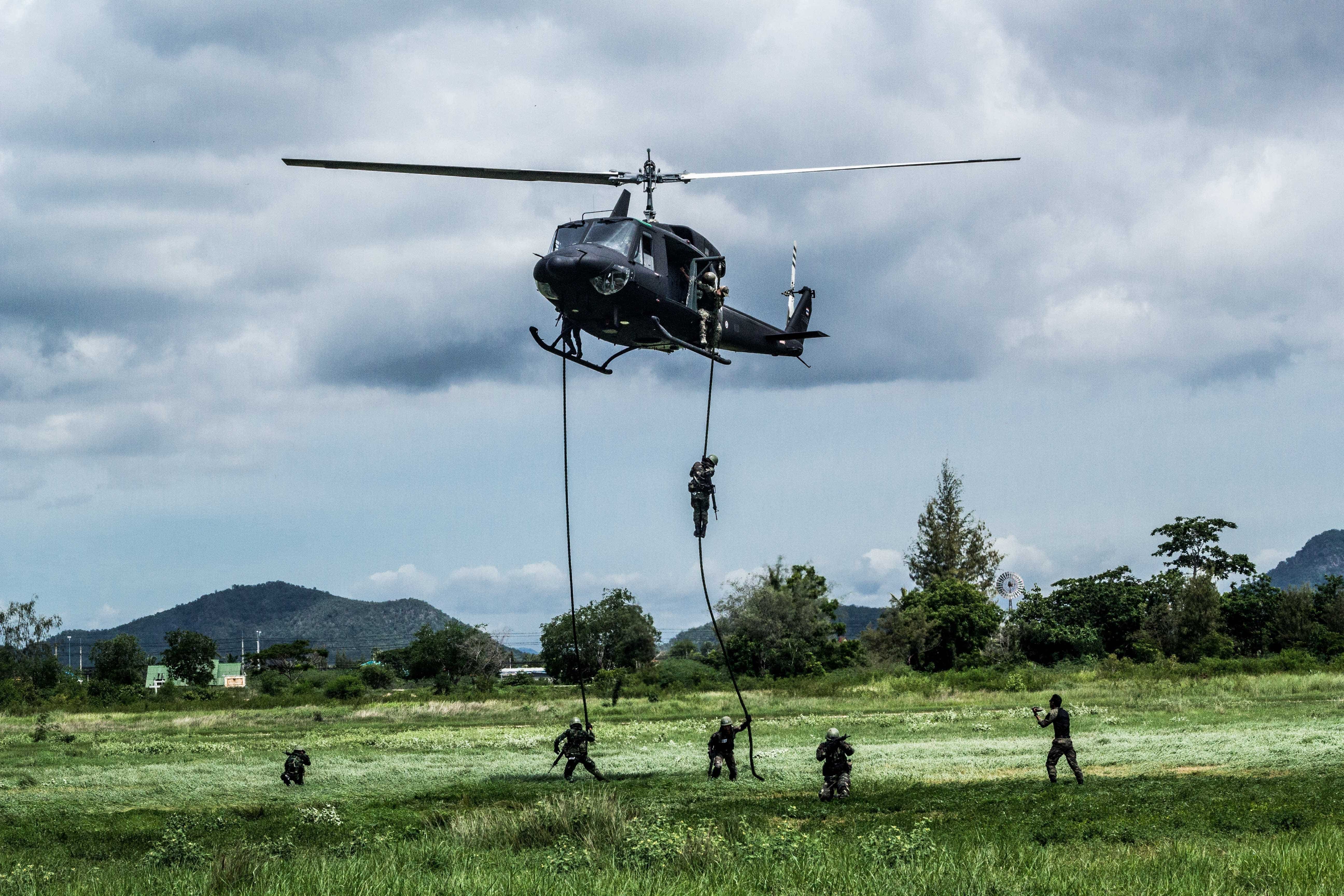 Helicopter hovering in place as a tactical unit rappels to the ground