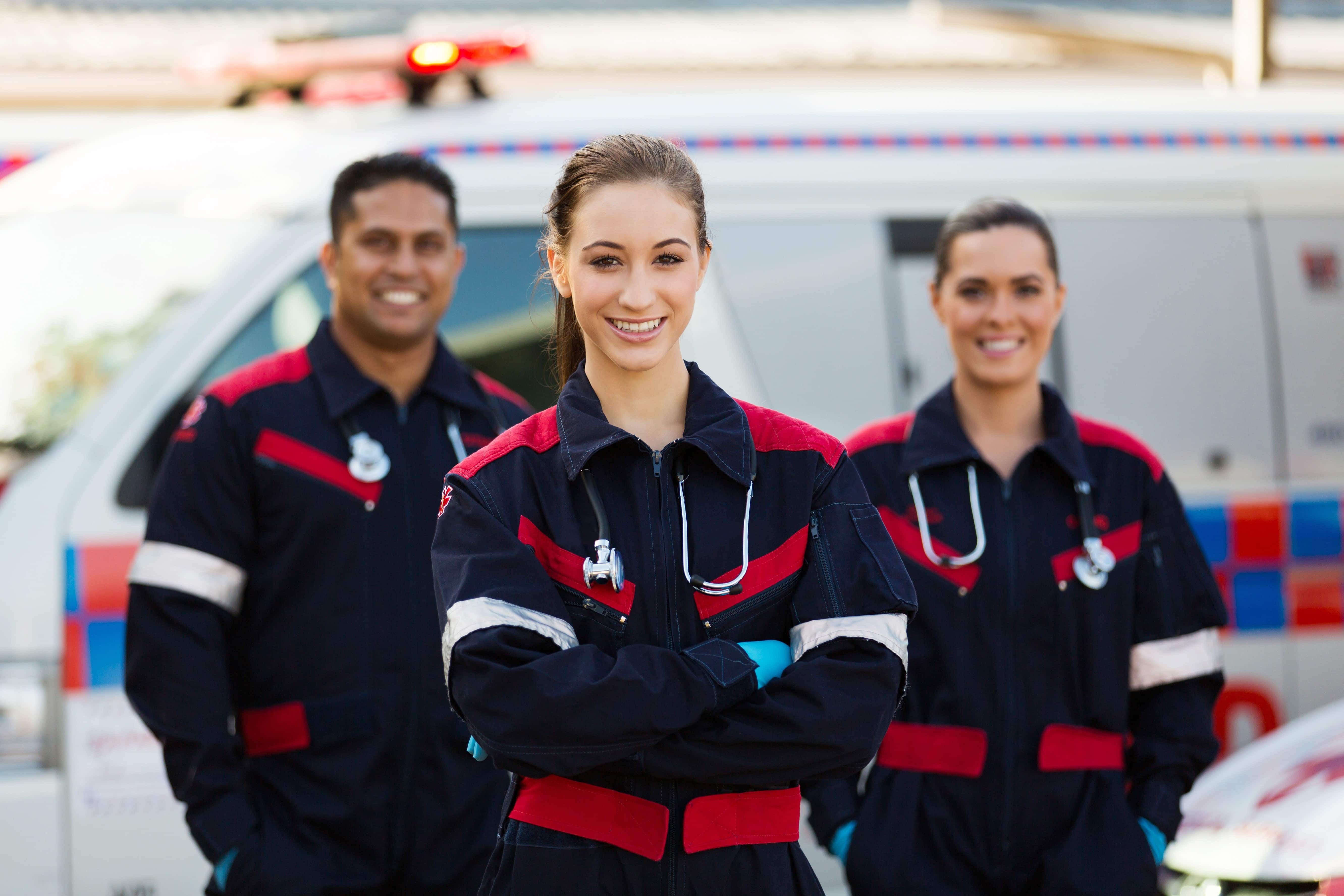 Team of EMS professionals standing beside an ambulance