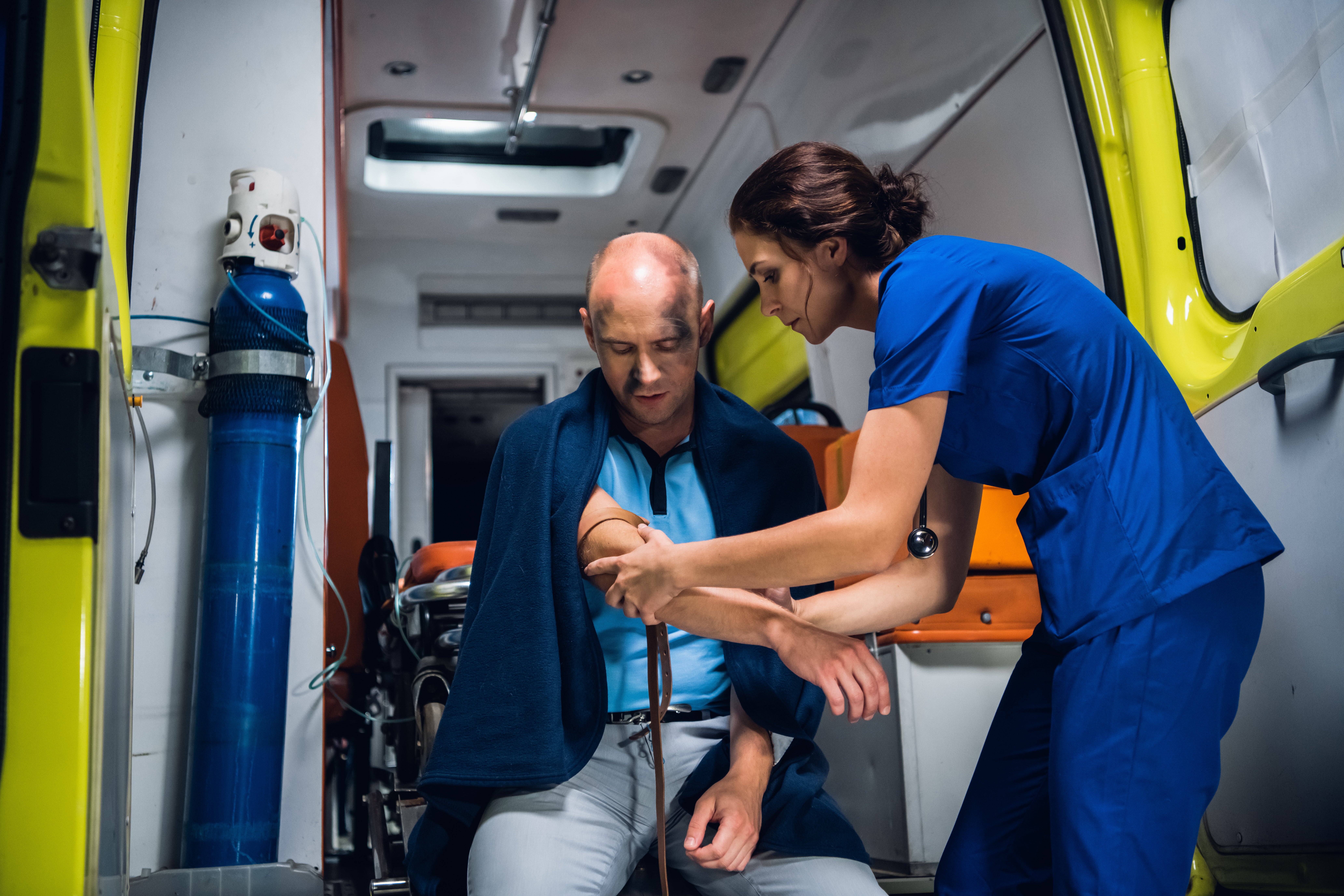 Medical professional treating an industrial worker in an ambulance