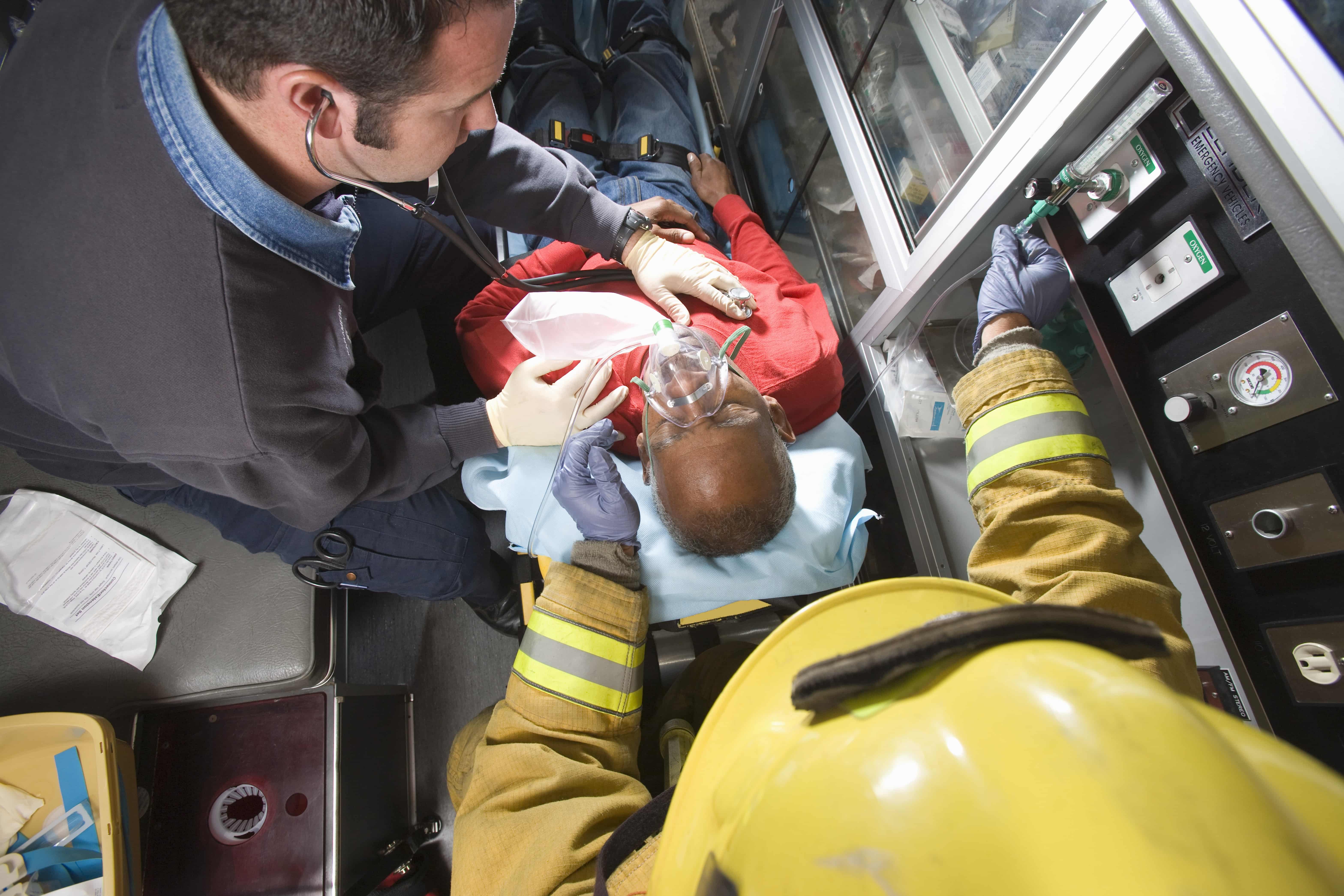 Overhead view of EMS professionals stabilizing a man in an ambulance