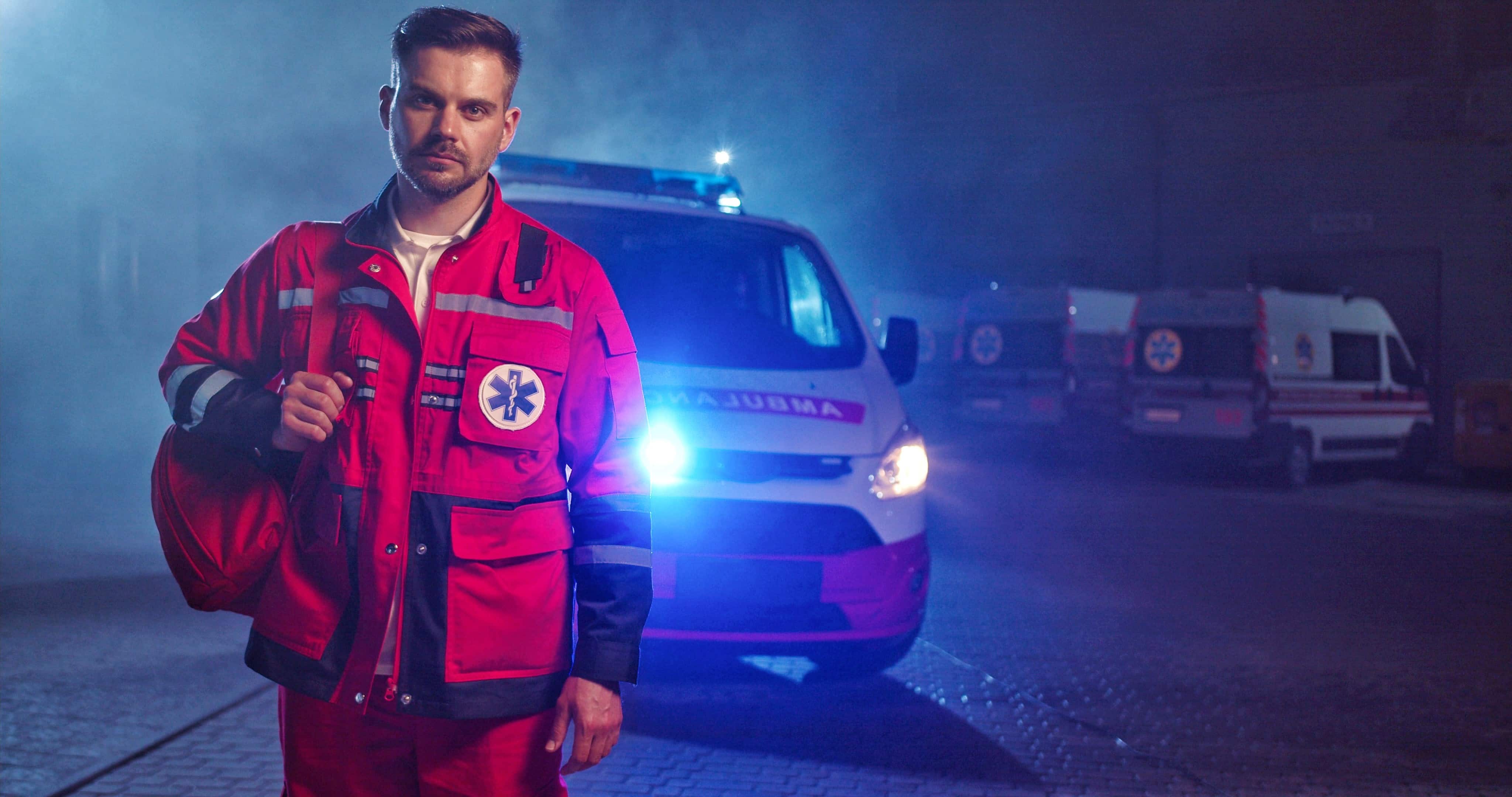 Male EMS professional standing in front of an ambulance