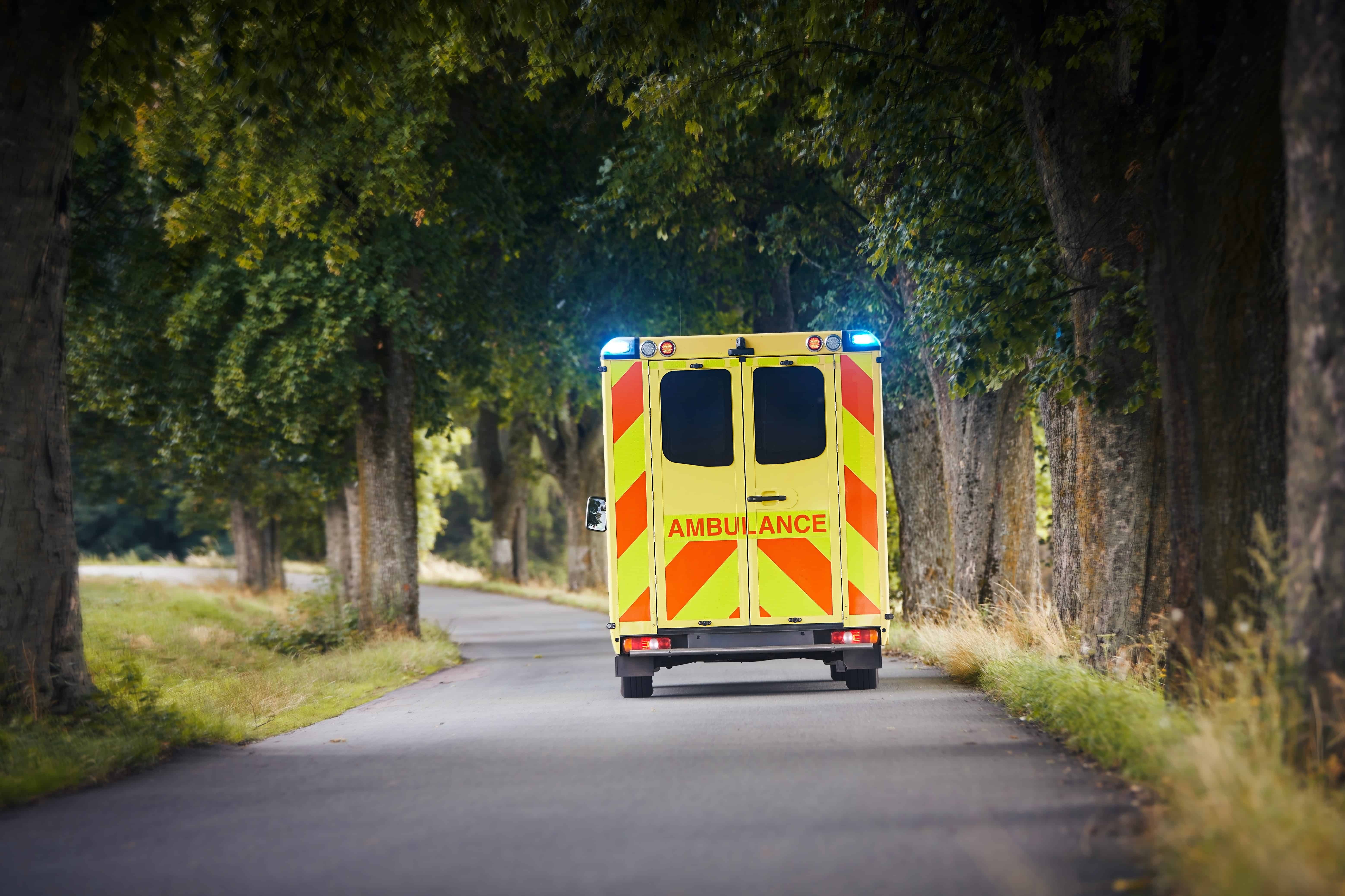 Ambulance driving on a country road in a rural area