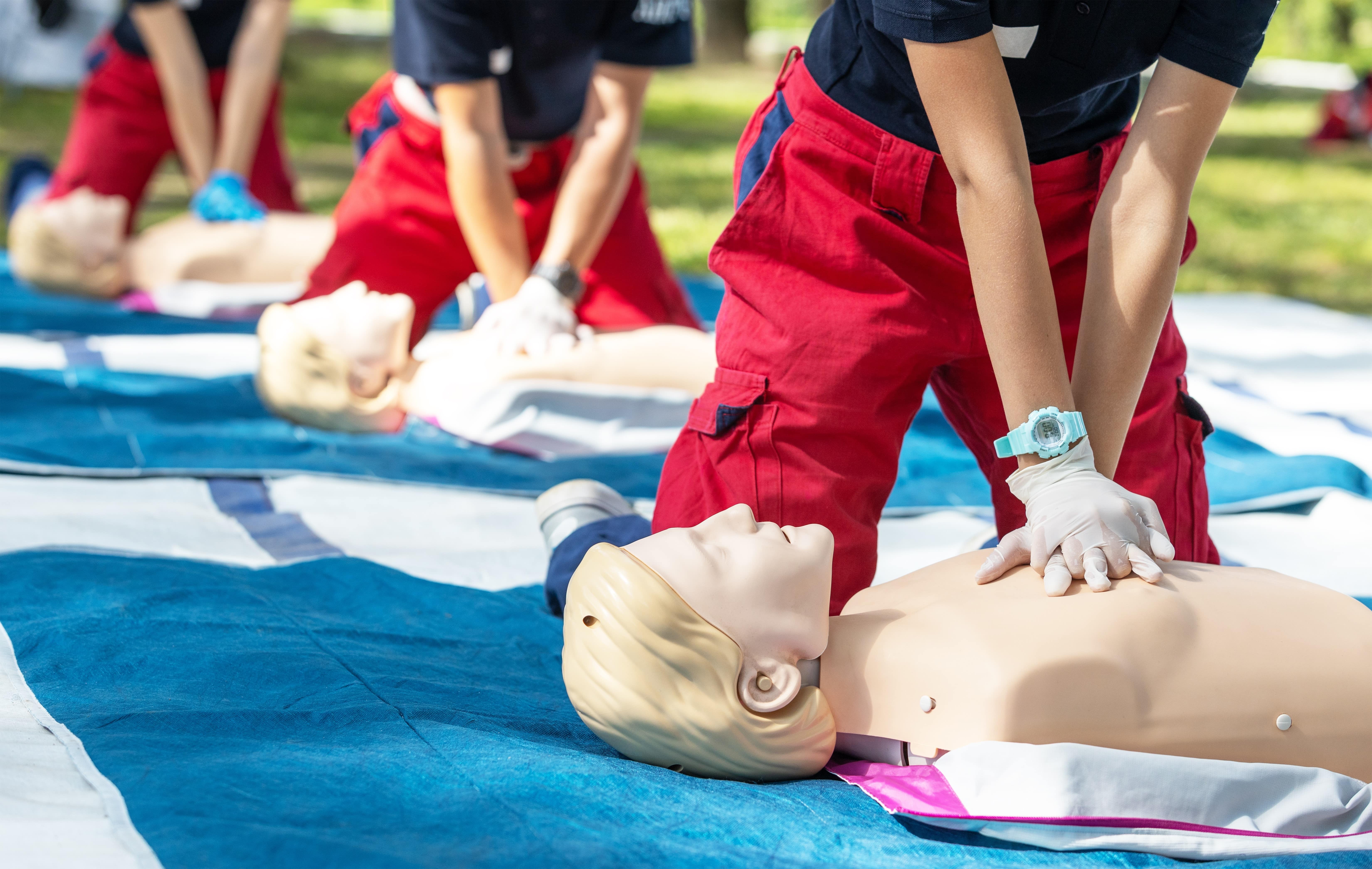 Close up of EMS students performing CPR on mannequins