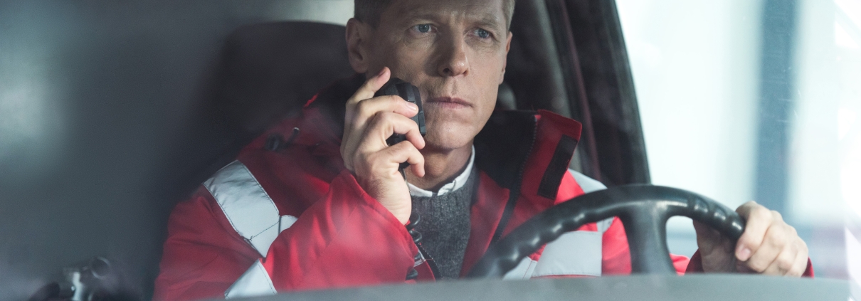 Male ambulance driver using a radio