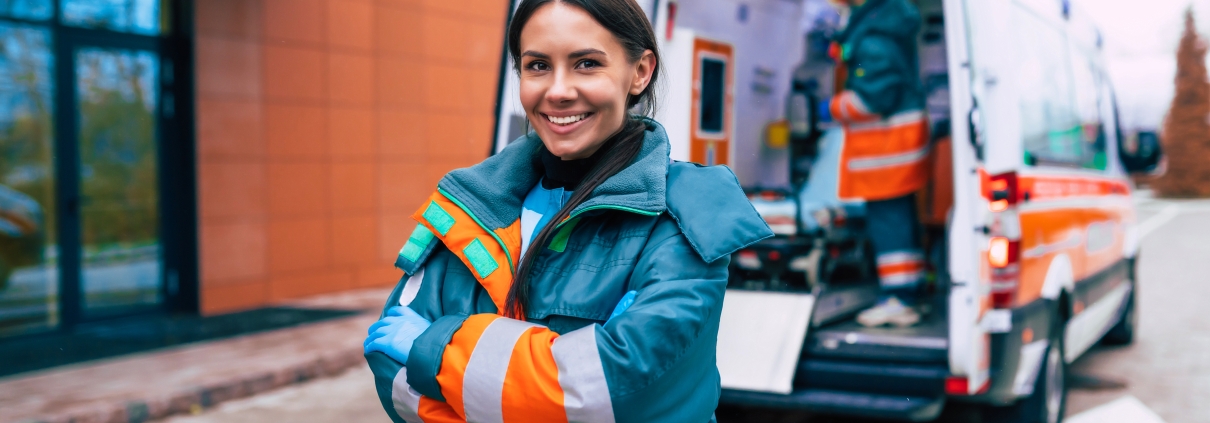 Smiling female EMS professional with arms crossed