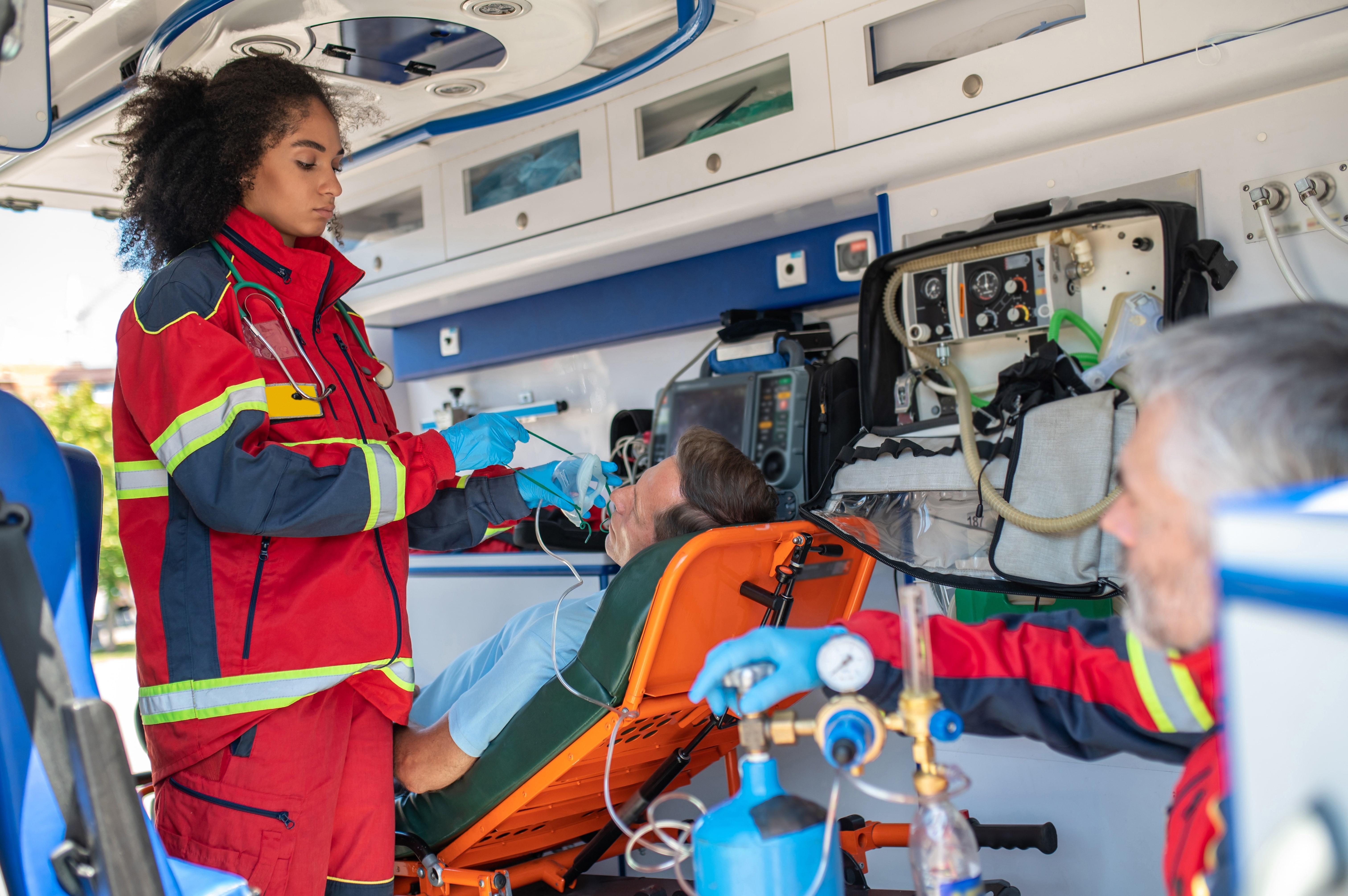 Female EMS professional applying an oxygen mask to a man's face