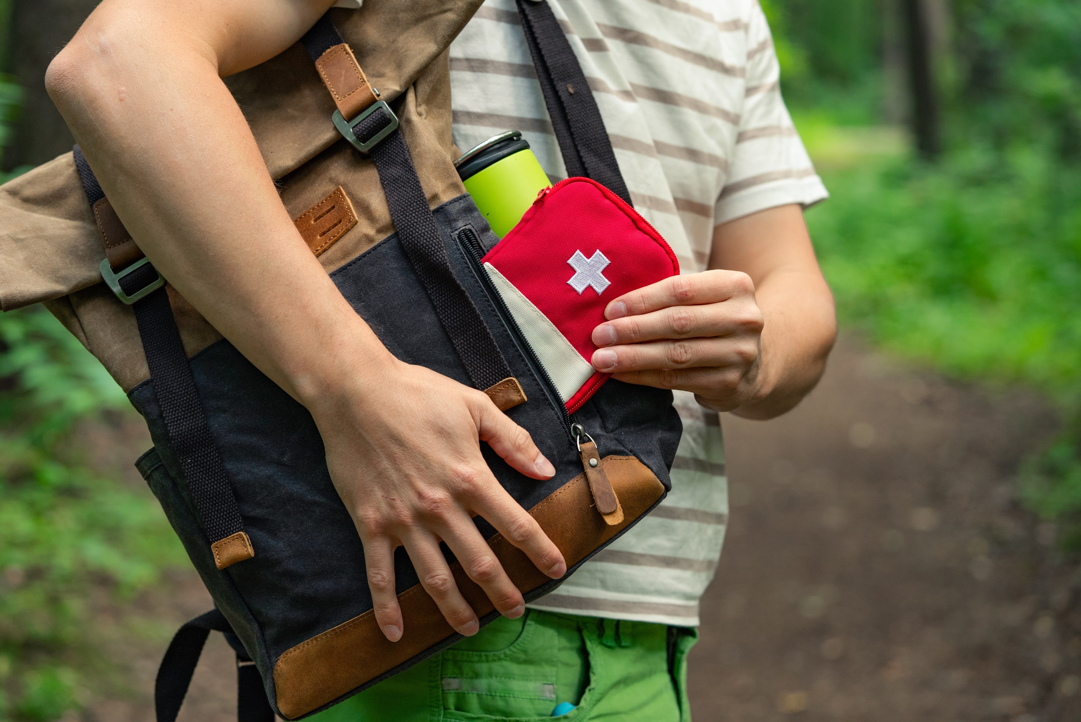 Close up of a man packing a first aid kit outside