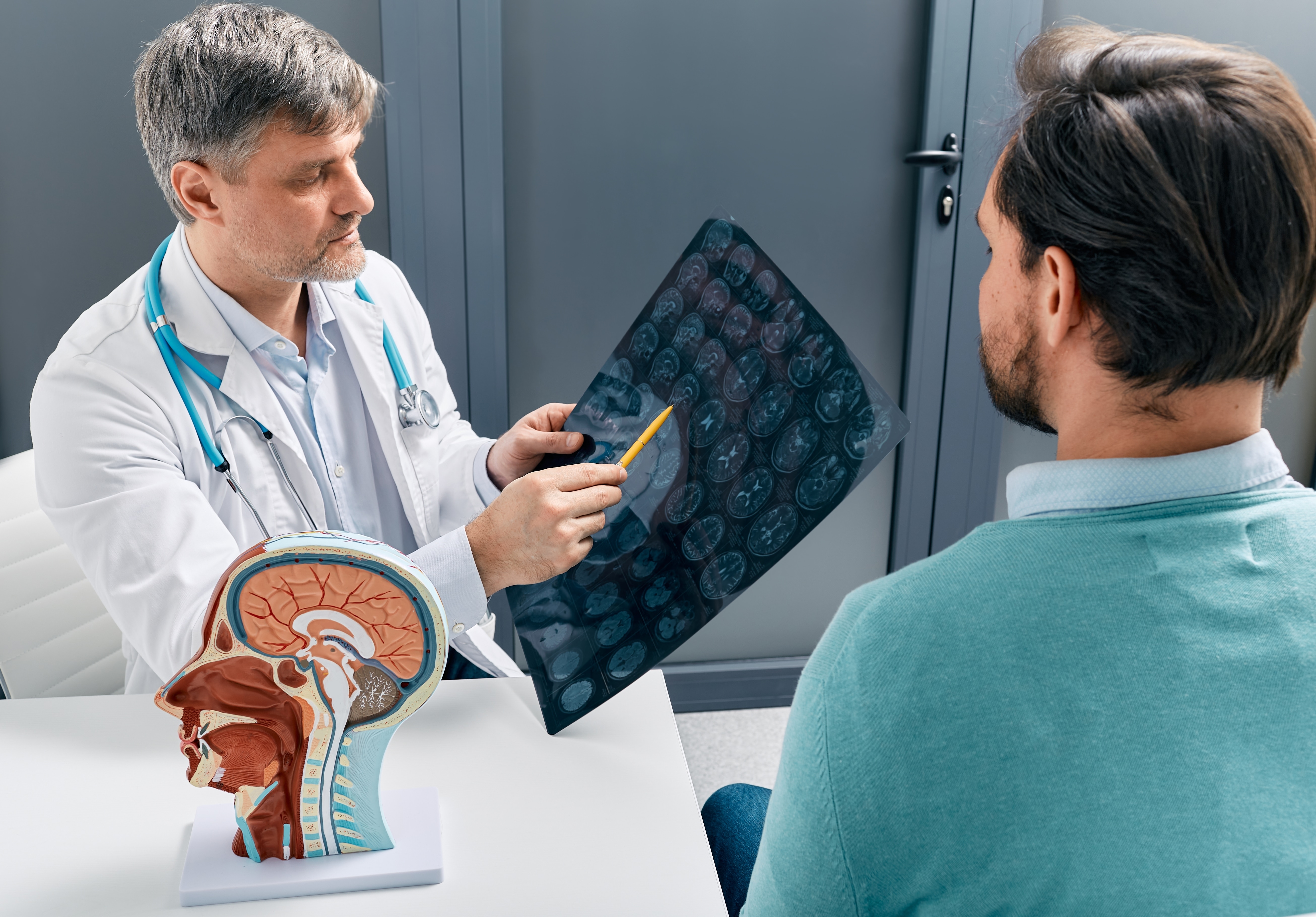 Medical professional examining a patient's brain scans