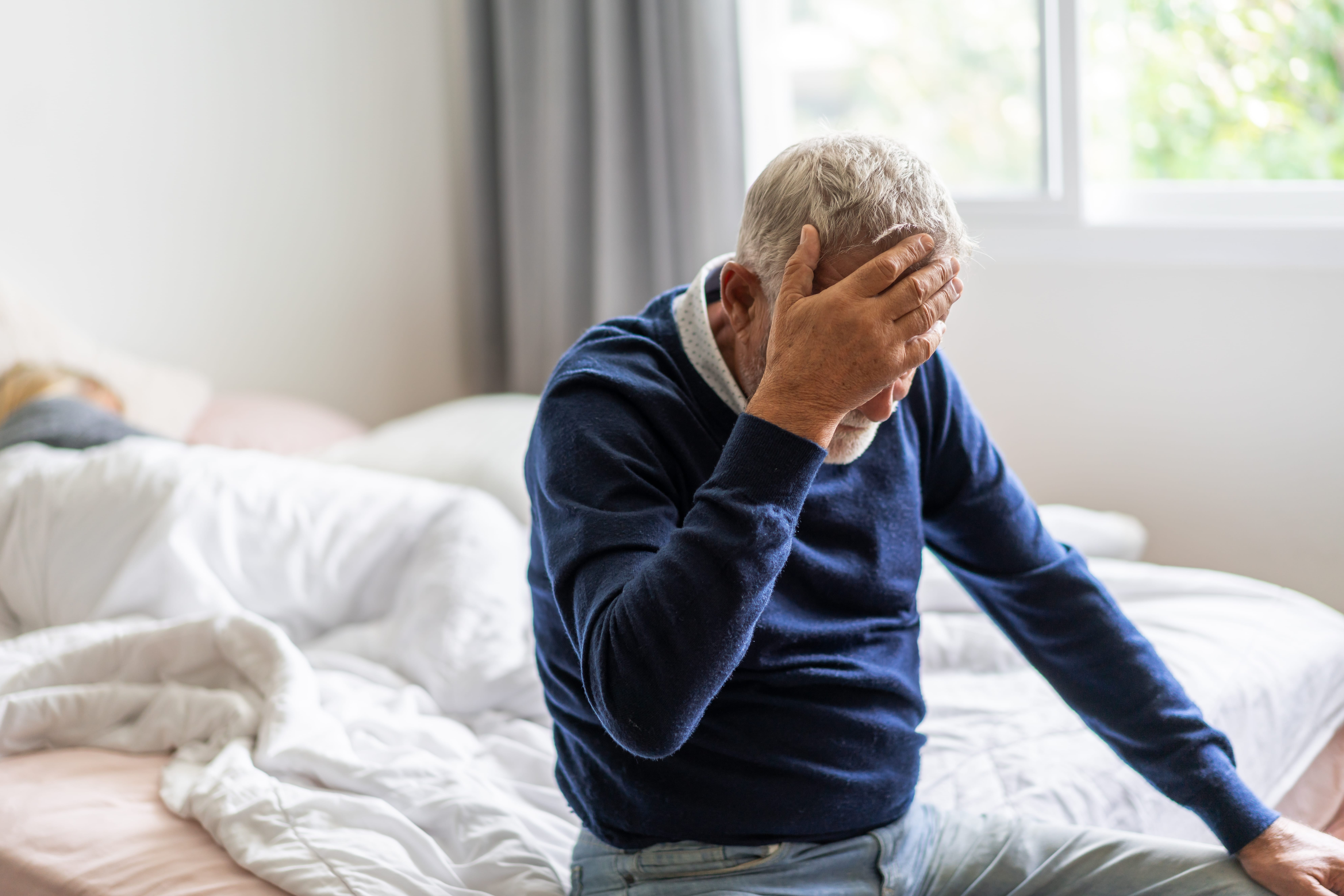 Senior man holding his head in pain during a stroke