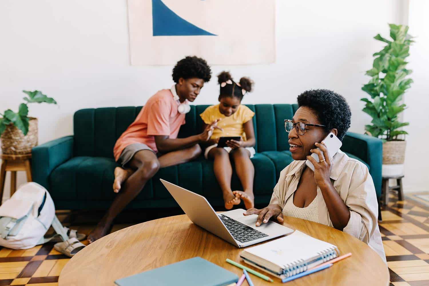 African-American woman using a laptop next to her children