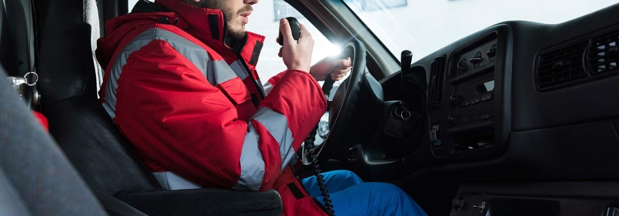 Male ambulance driver using a radio