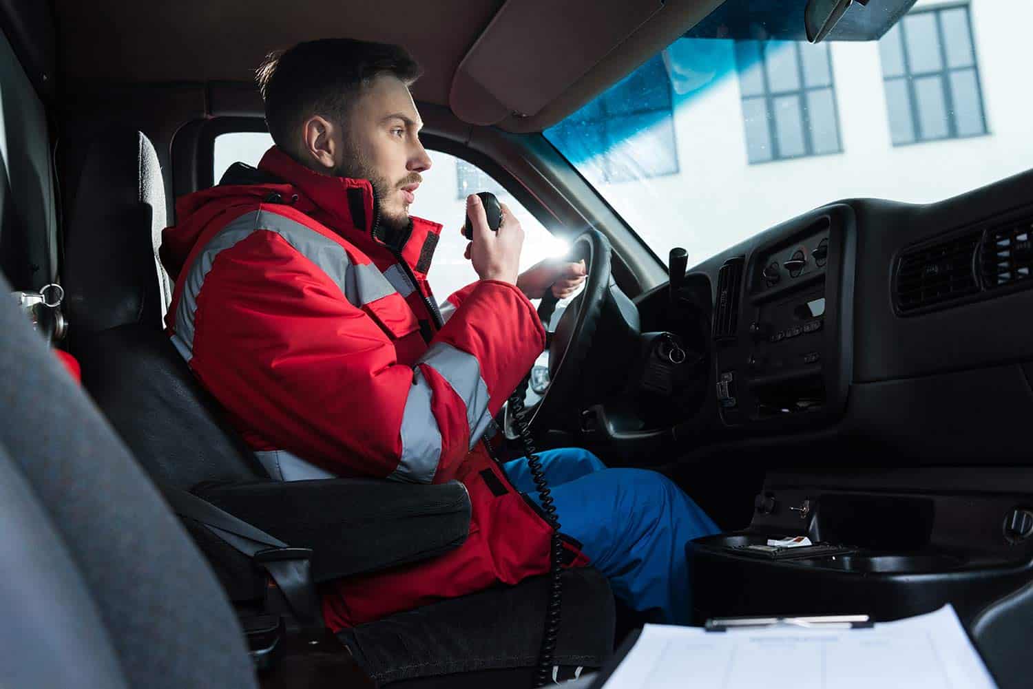 Male ambulance driver using a radio