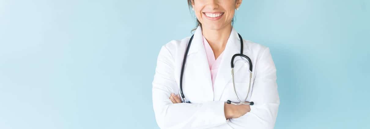 Female medical professional in a lab coat with her arms crossed